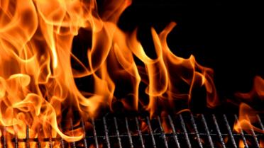 vlammen door de bbq-grill