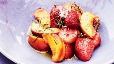 Gebakken perziken, aardbeien en bessen met rozemarijn