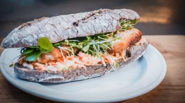 Broodje met gepaneerde vis en wortelsalade