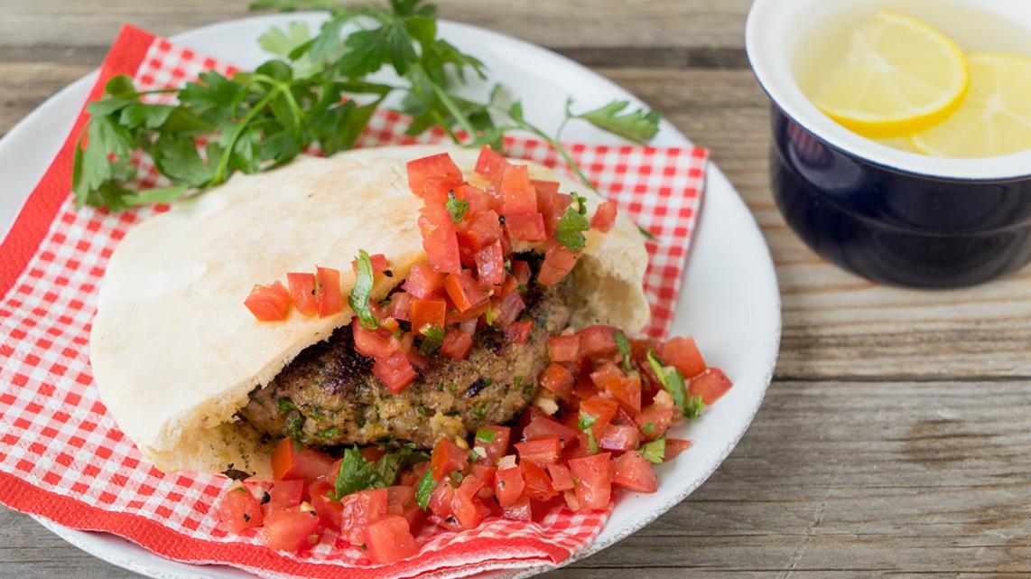 Pitabroodje gevuld met pestoburger en tomaten