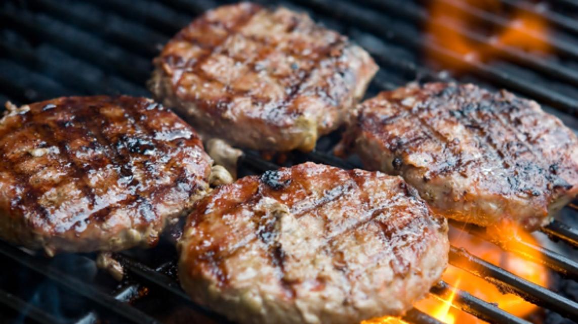 Gegrilde hamburger met aardappelen op de barbecue